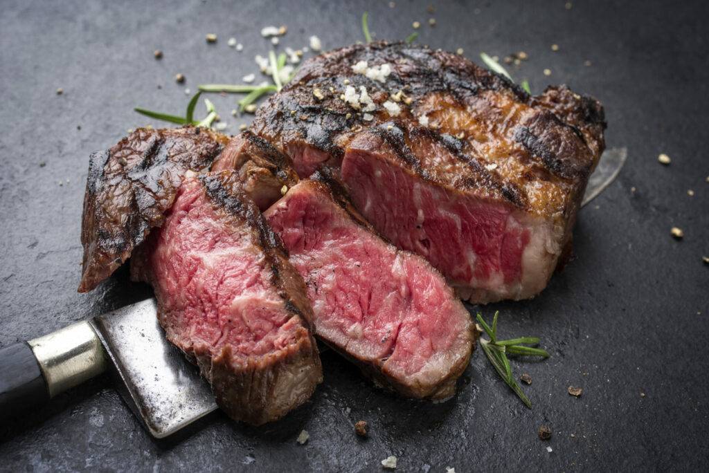 barbecue aged wagyu rib eye steak as close-up on slate